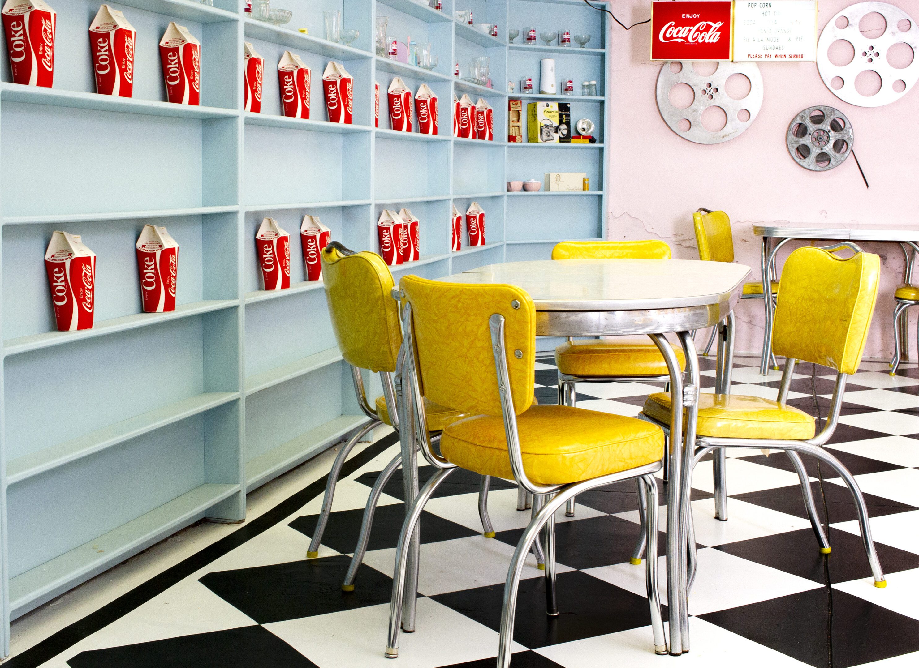 Retro diner with yellow chairs and checkered floor.