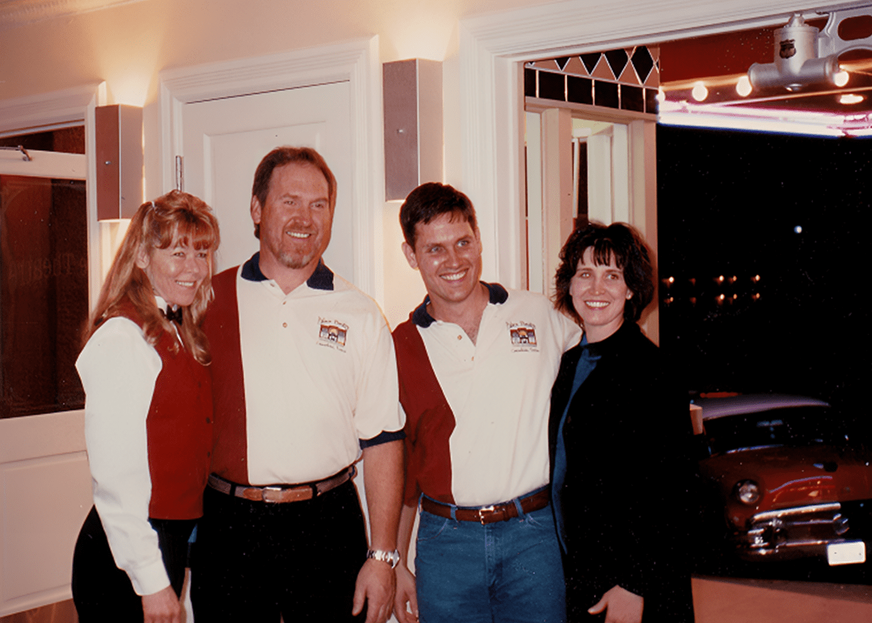 Group of people smiling indoors at night.