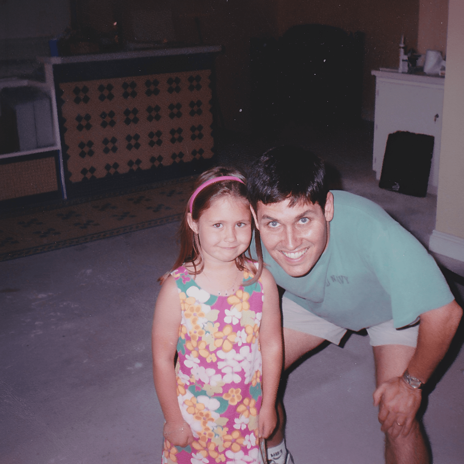 Man and girl smiling indoors.