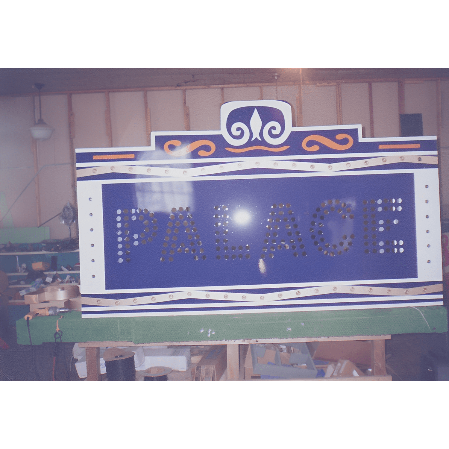 Vintage 'Palace' sign in workshop setting.