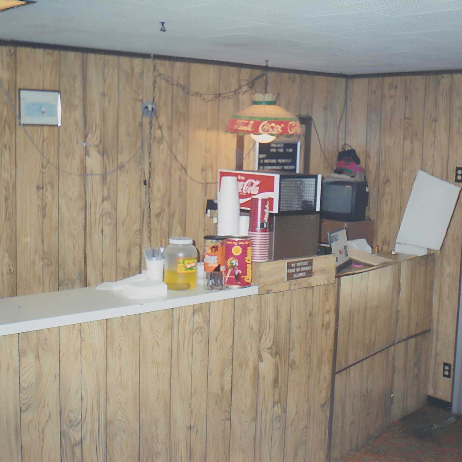 Wood-paneled counter with soda machine.